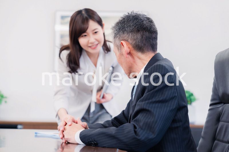 役員に報告をする秘書の女性