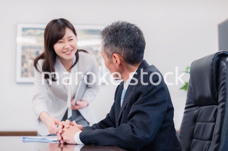 役員に報告をする秘書の女性
