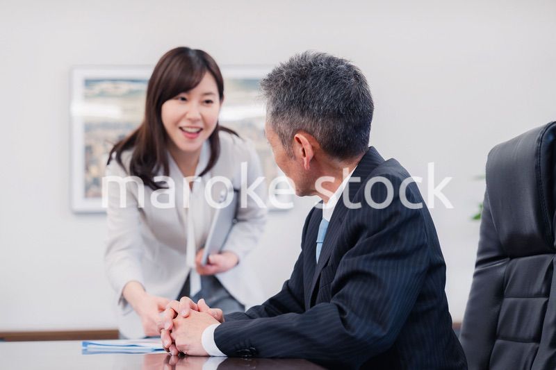 役員に報告をする秘書の女性