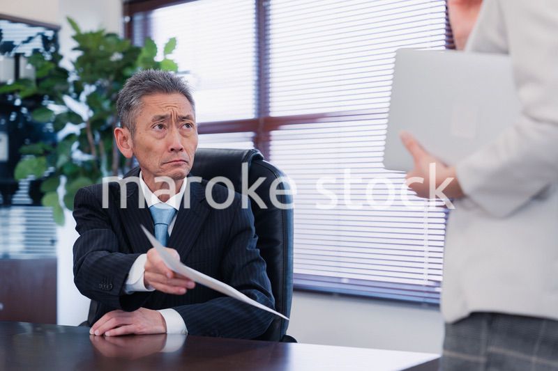 書類を突き返す会社役員の男性