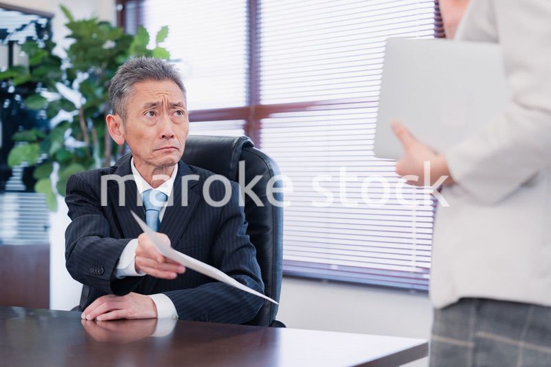 書類を突き返す会社役員の男性