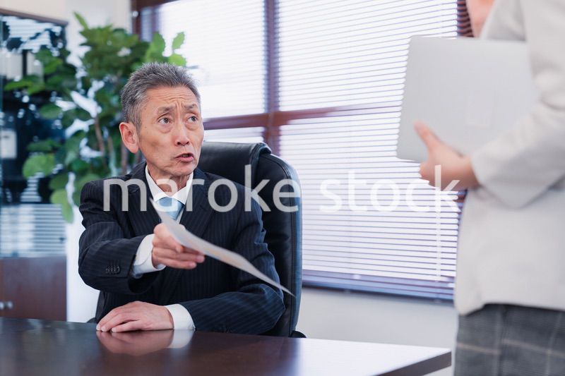 書類を突き返す会社役員の男性