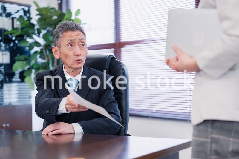書類を突き返す会社役員の男性