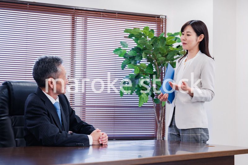 女性秘書と笑顔で話す男性