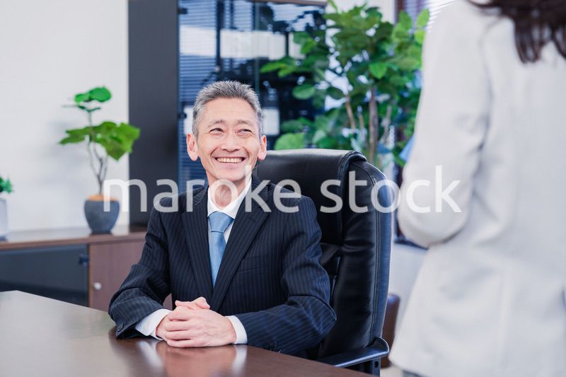 女性秘書と笑顔で話す男性