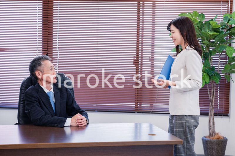 女性秘書と笑顔で話す男性