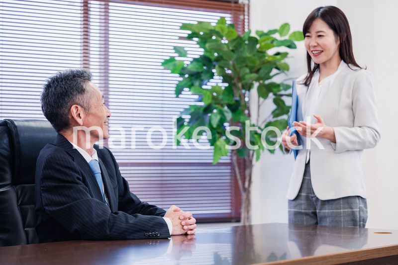 女性秘書と笑顔で話す男性