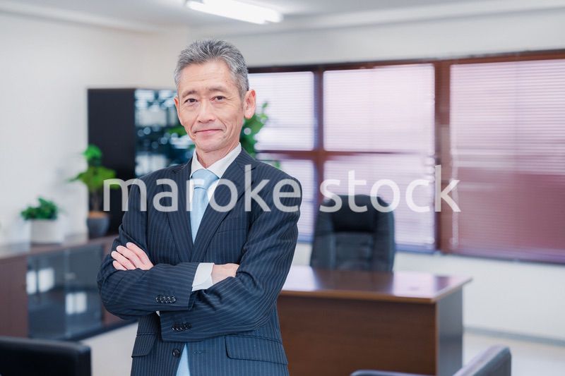 役員室で腕を組む経営者