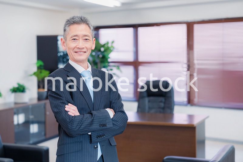 役員室で腕を組む経営者