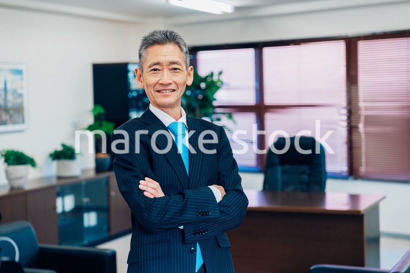 役員室で腕を組む経営者