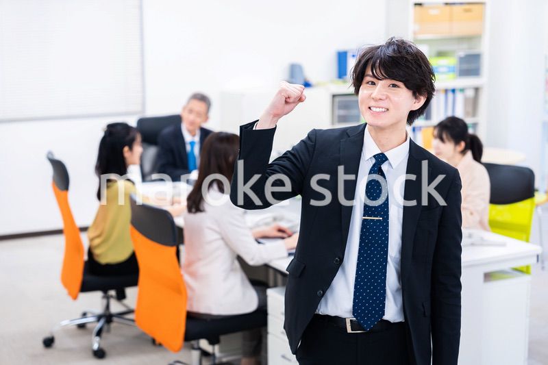 笑顔でガッツポーズをする若いビジネスマン