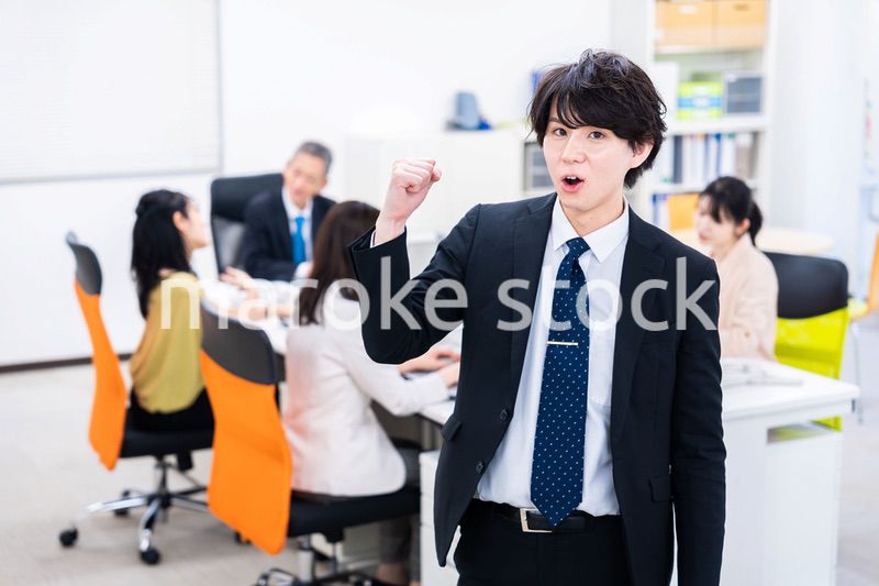 笑顔でガッツポーズをする若いビジネスマン