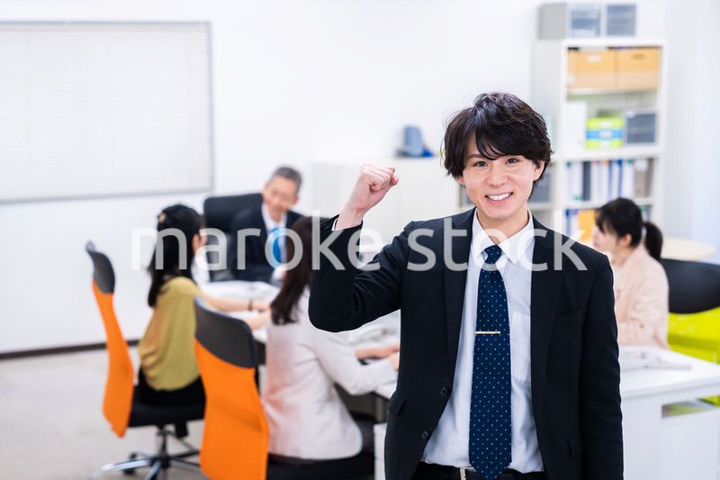 笑顔でガッツポーズをする若いビジネスマン