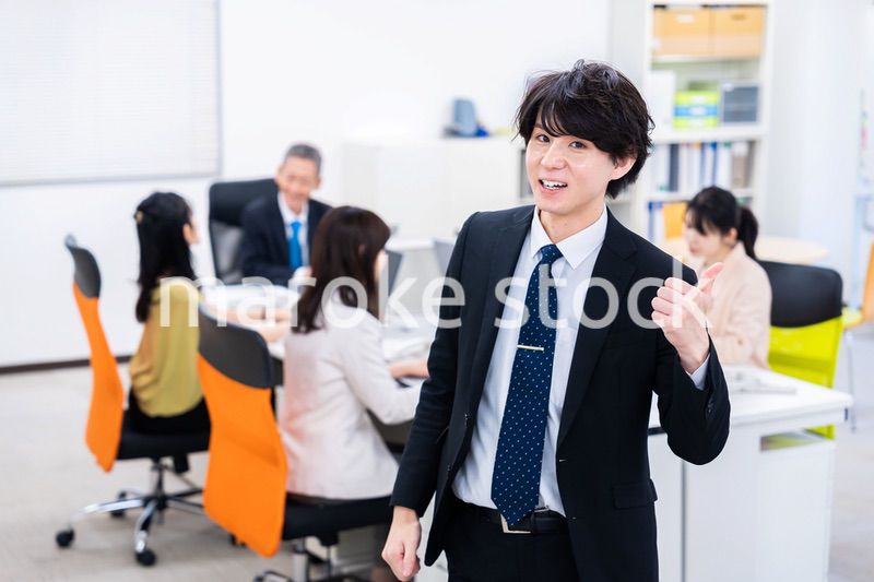 笑顔でグッドサインをする若いビジネスマン