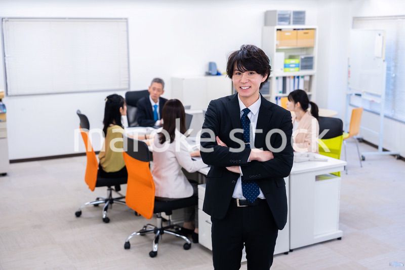 笑顔で腕を組む若いビジネスマン