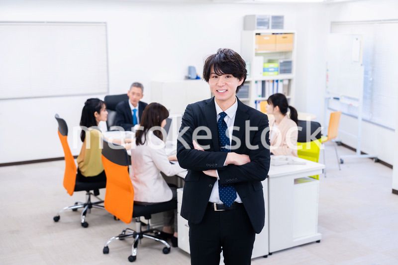 笑顔で腕を組む若いビジネスマン