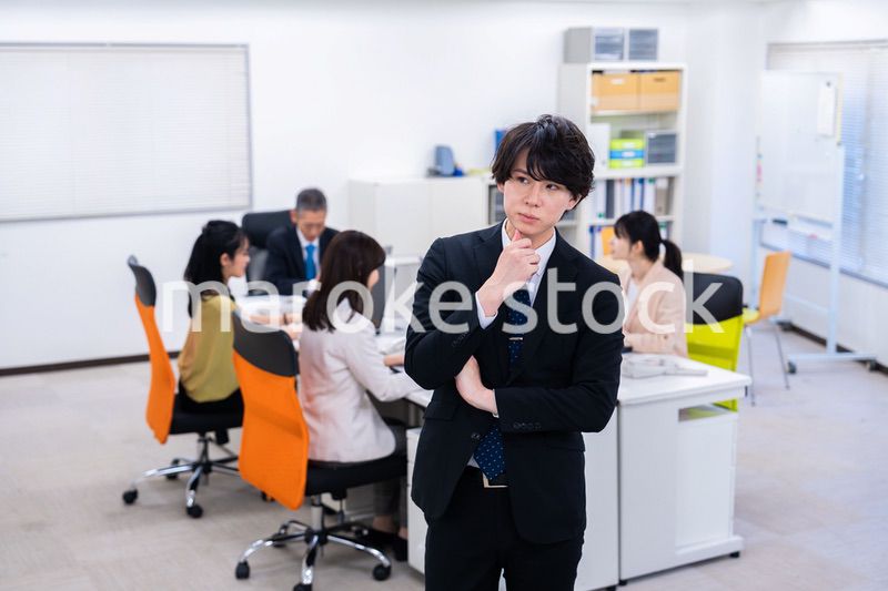 腕を組んで悩む若いビジネスマン