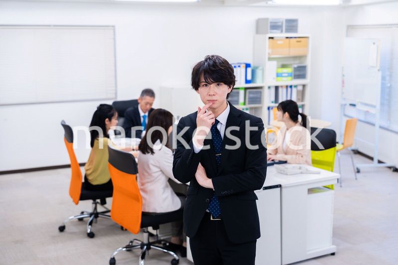 腕を組んで悩む若いビジネスマン