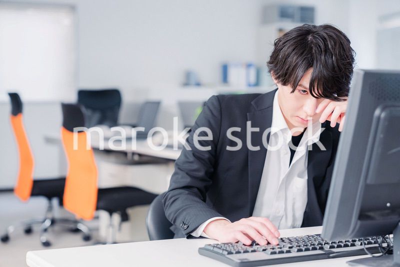 遅い時間まで一人で残業をするビジネスパーソン