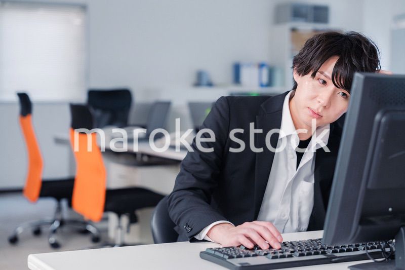 遅い時間まで一人で残業をするビジネスパーソン