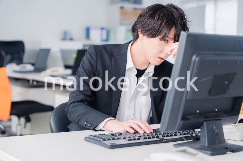 遅い時間まで一人で残業をするビジネスパーソン