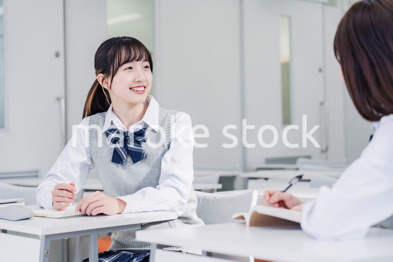 教室で休み時間に話す女子高生