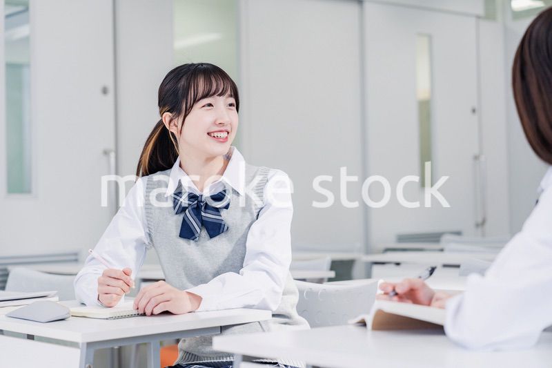 教室で休み時間に話す女子高生