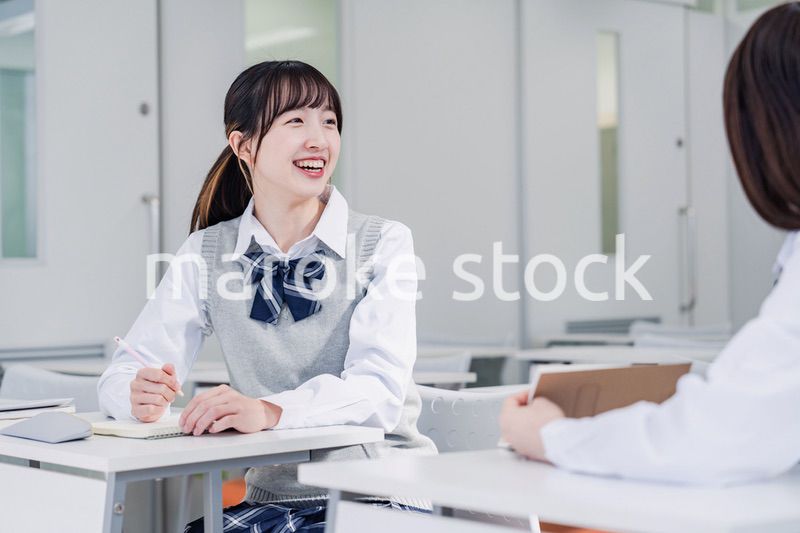 教室で休み時間に話す女子高生