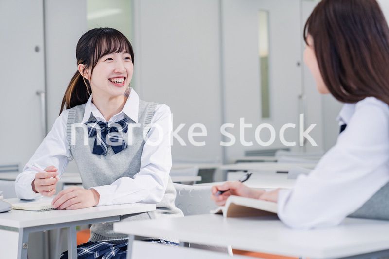 教室で休み時間に話す女子高生