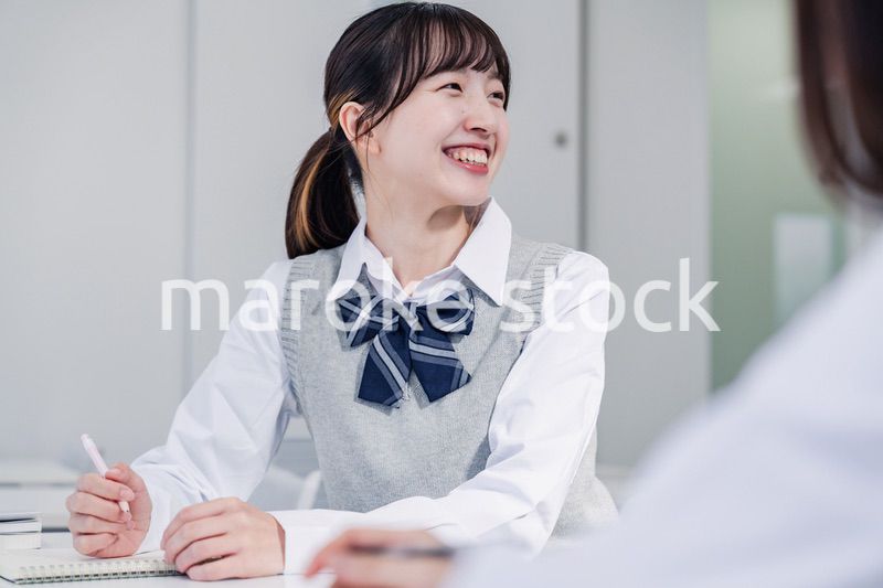 教室で休み時間に話す女子高生