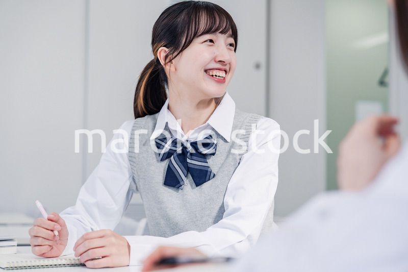 教室で休み時間に話す女子高生