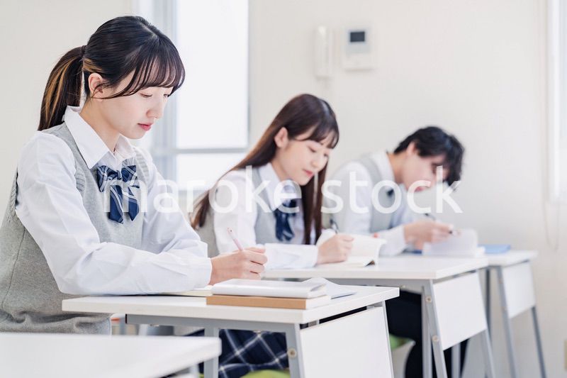 集中してノートを取る高校生