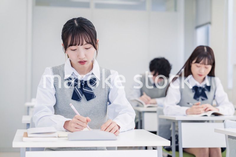 集中してノートを取る高校生