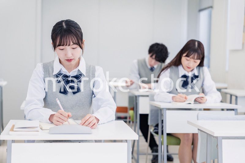 集中してノートを取る高校生