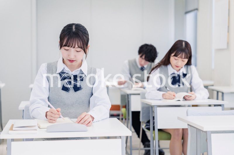 集中してノートを取る高校生