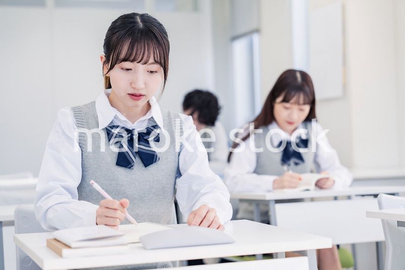 集中してノートを取る高校生