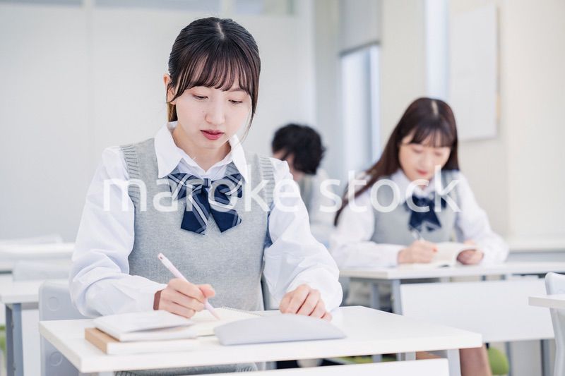 集中してノートを取る高校生