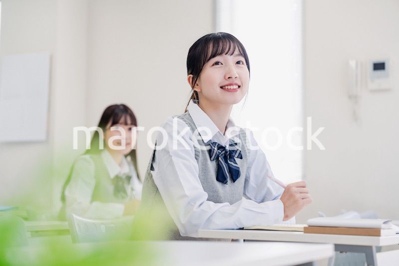 教室でにこやかに授業を受ける女子高生