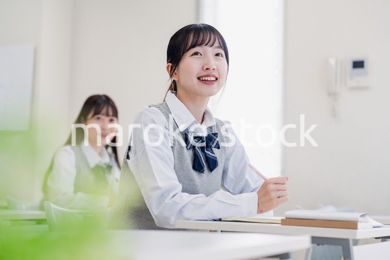教室でにこやかに授業を受ける女子高生