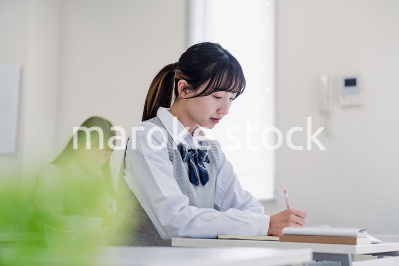 集中してノートを取る高校生