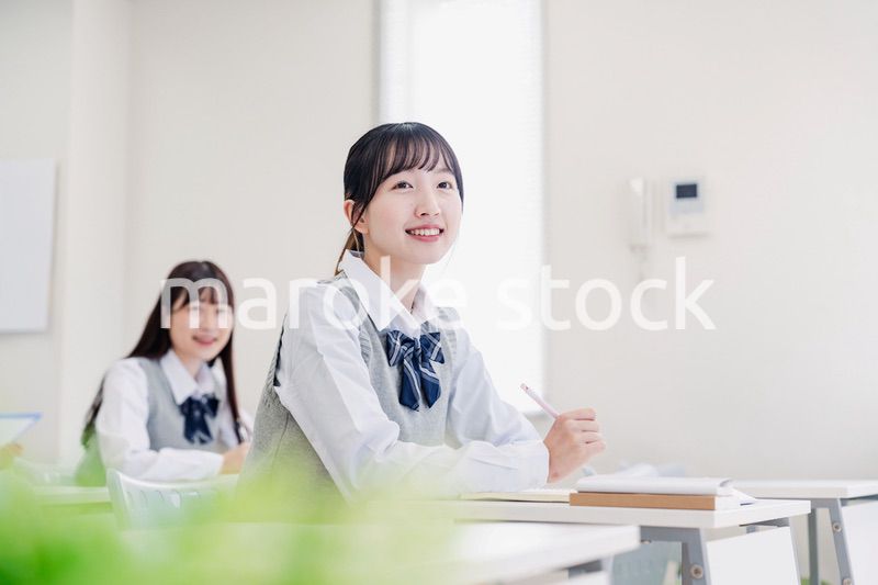 教室でにこやかに授業を受ける女子高生