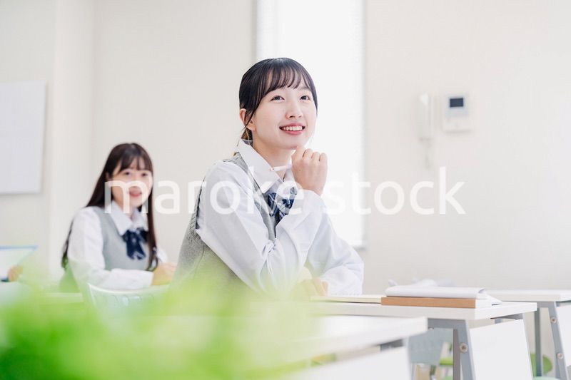 教室でにこやかに授業を受ける女子高生