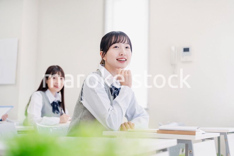 教室でにこやかに授業を受ける女子高生