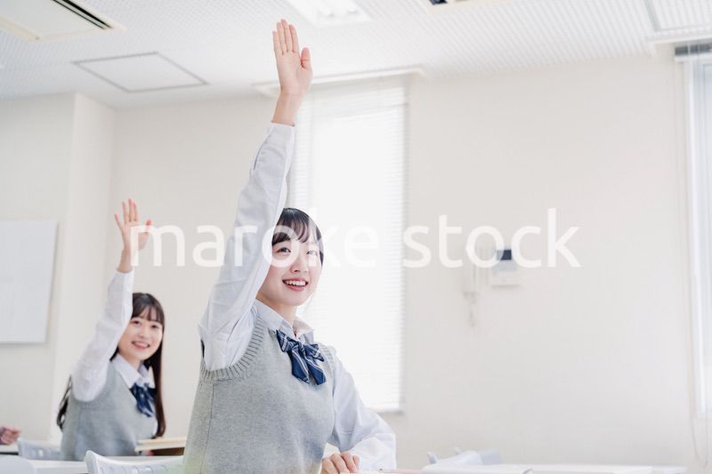 手を上げて発表をする女子高生