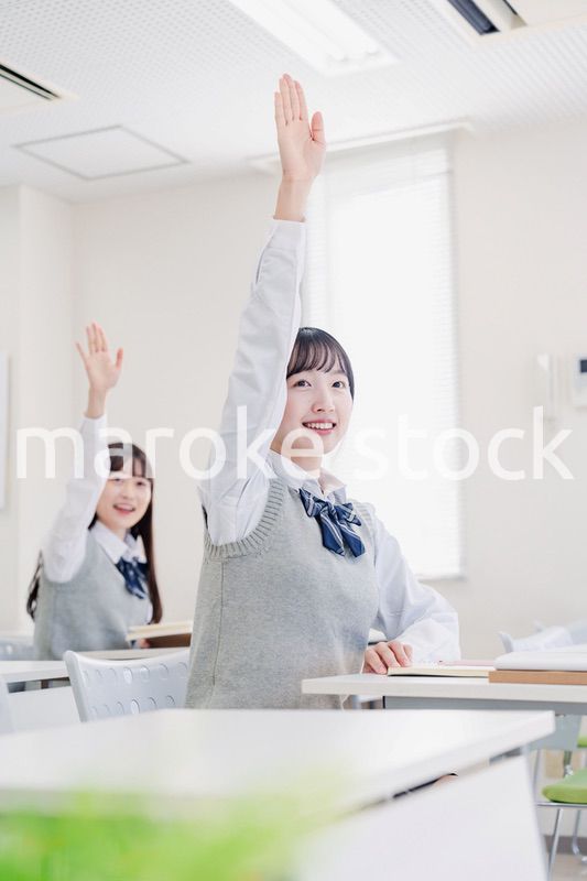 手を上げて発表をする女子高生