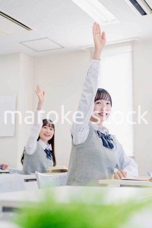 手を上げて発表をする女子高生