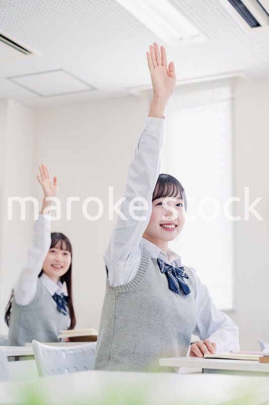 手を上げて発表をする女子高生