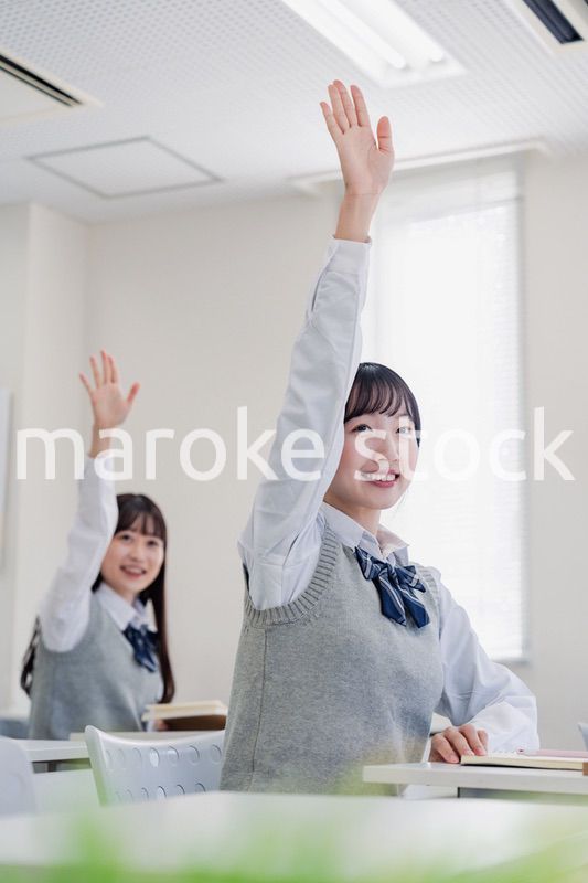 手を上げて発表をする女子高生