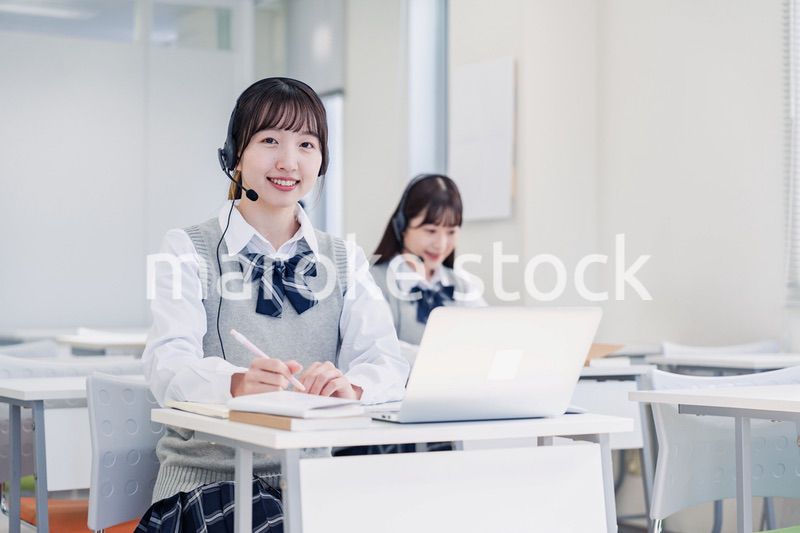 教室でノートパソコンを使う女子高生