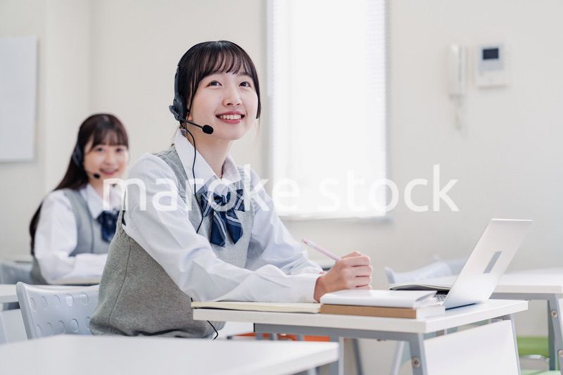 教室でノートパソコンを使う女子高生